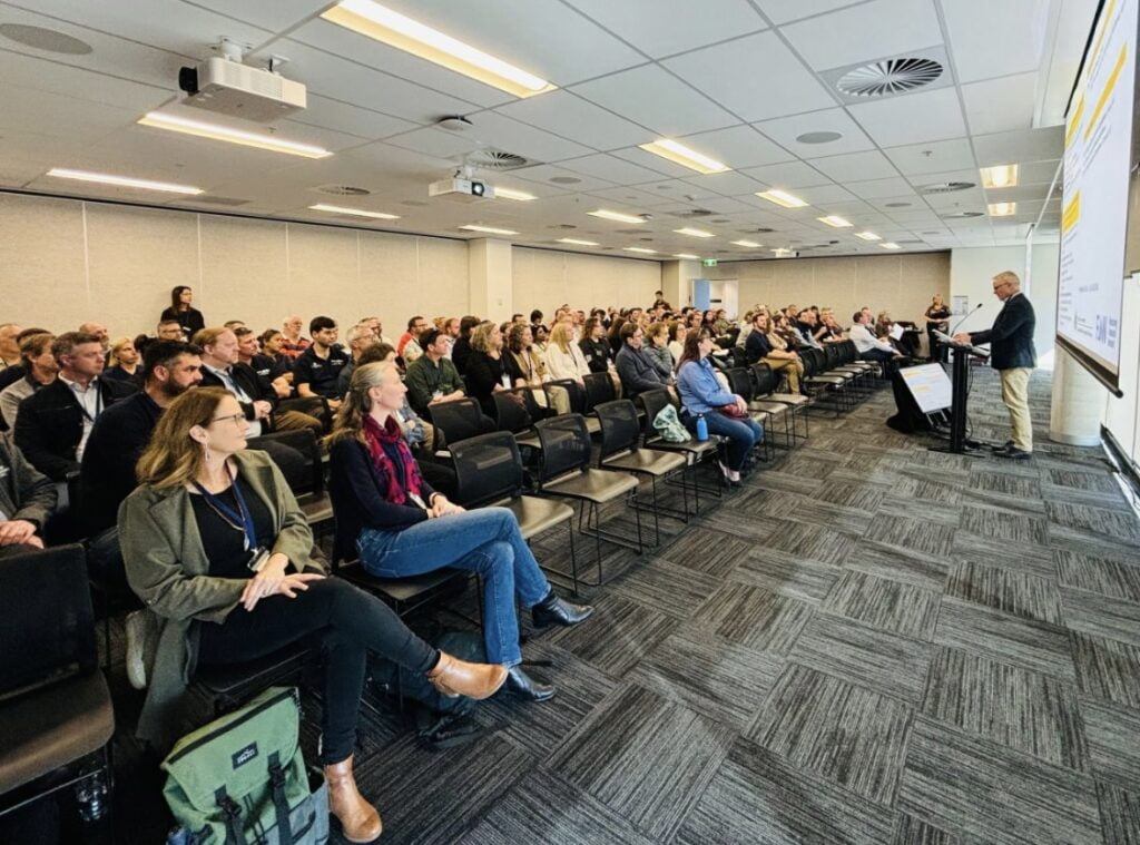 Scientists, interested members of the public and speakers sit at the Flow-MER Forum 2024, held on Ngunnawal Country.